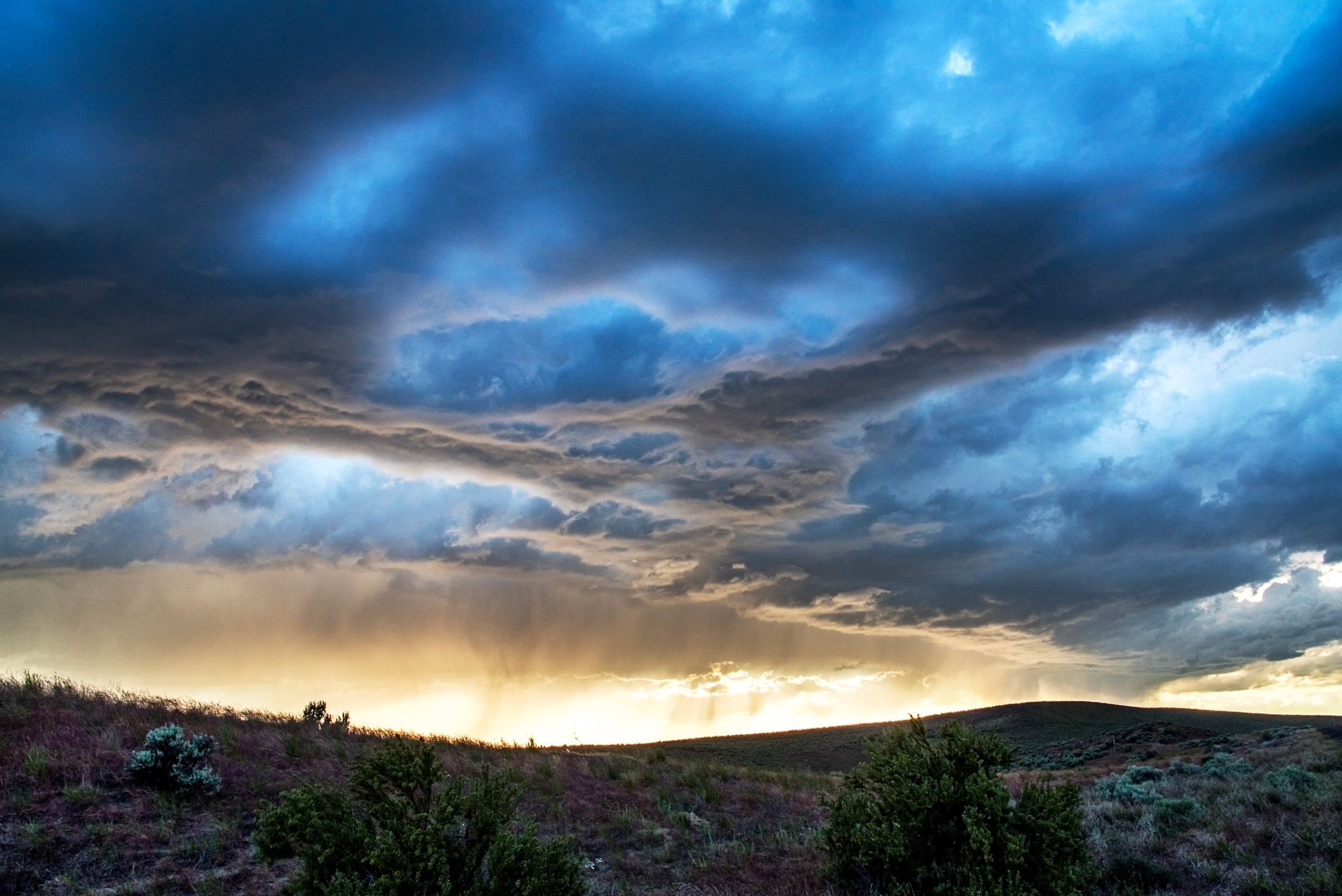 Curtains of Rain — A storm drags curtains of rain across the golden horizon near Boise, Idaho