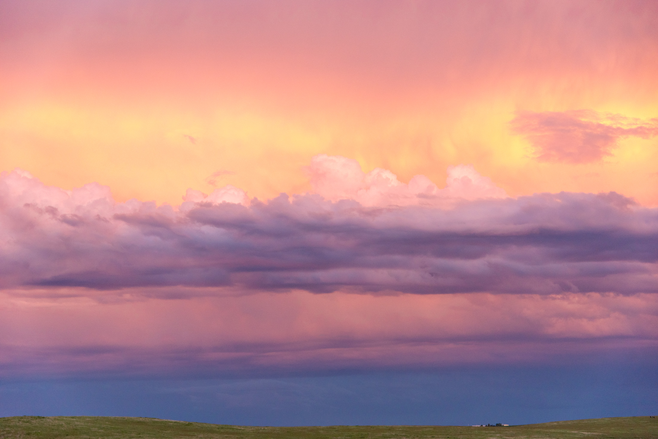 Pastel Clouds — Bands of pink and violet cloud drift over the South Dakota prairie at dusk