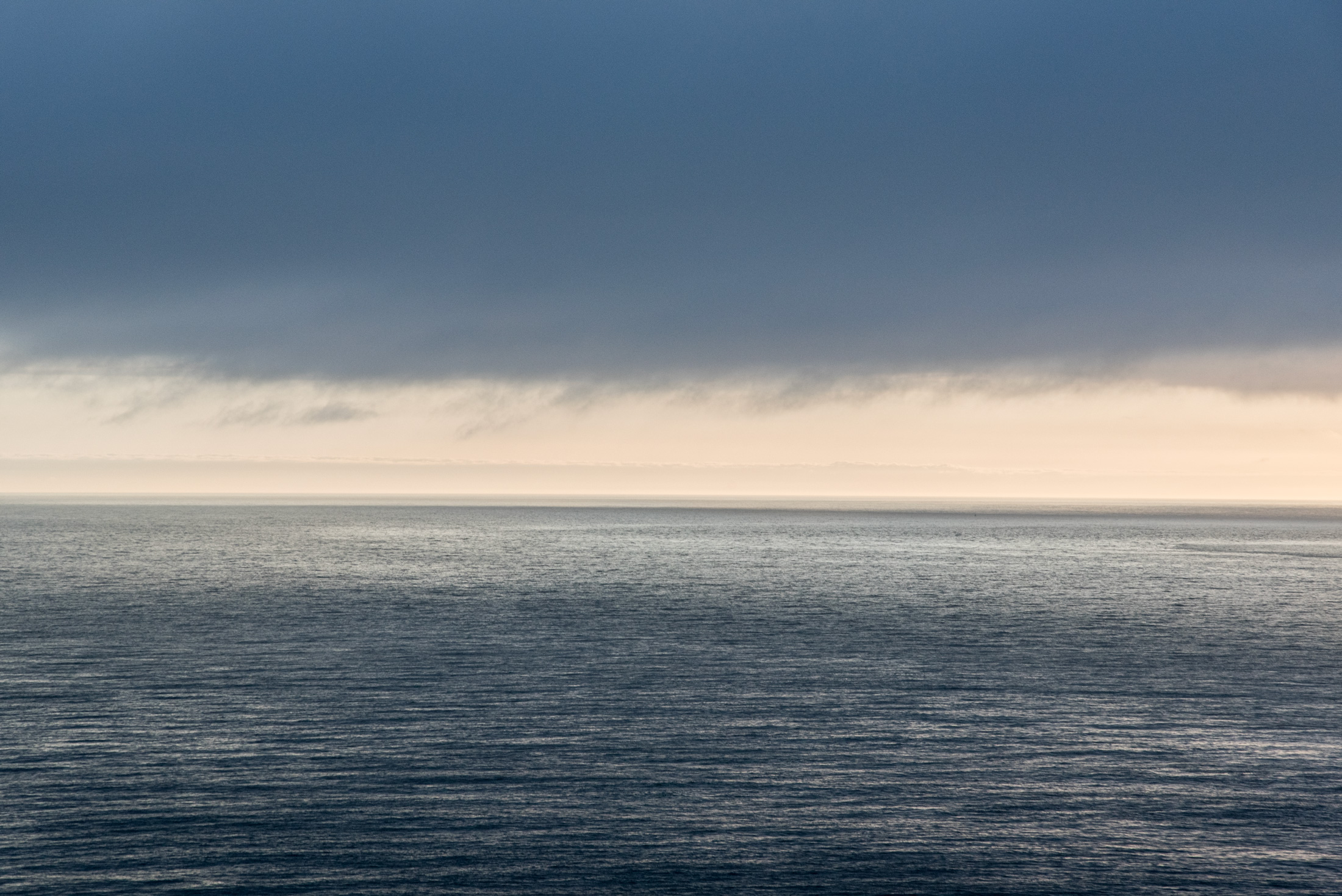 Where Light and Shadow Meet — The waters of San Francisco Bay reflect the fading light of evening beneath a dramatic sky along the horizon.