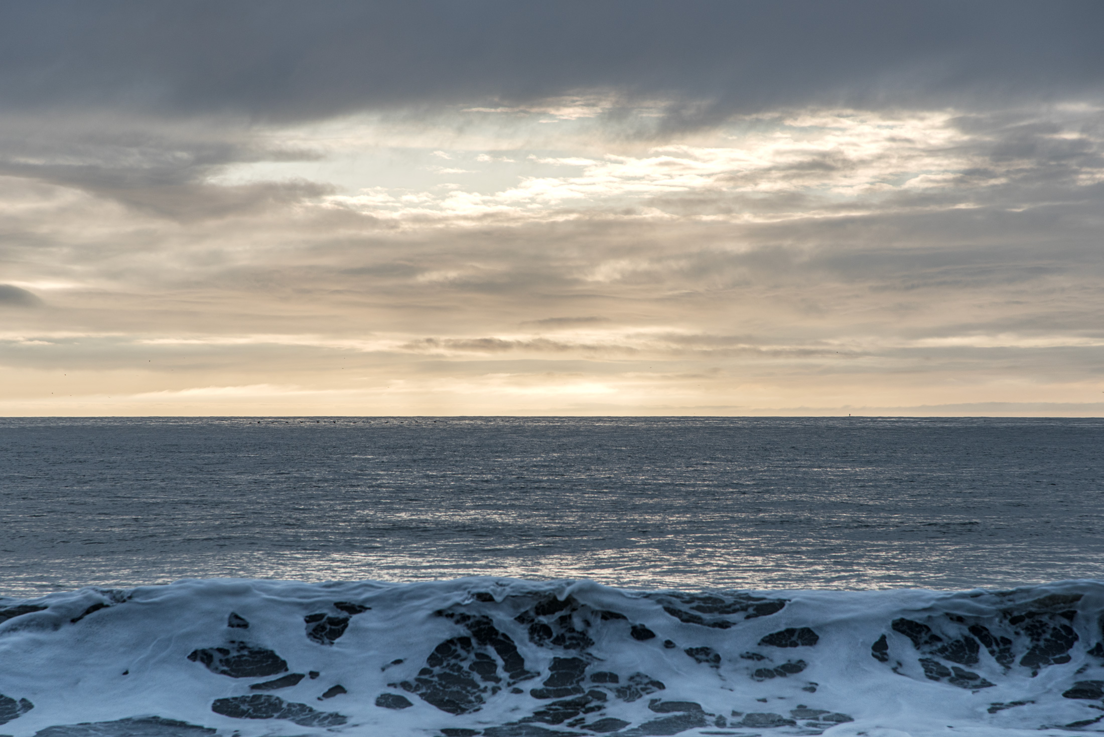 Golden Hour on the Bay — Surf breaks white beneath a golden evening sky on San Francisco Bay.
