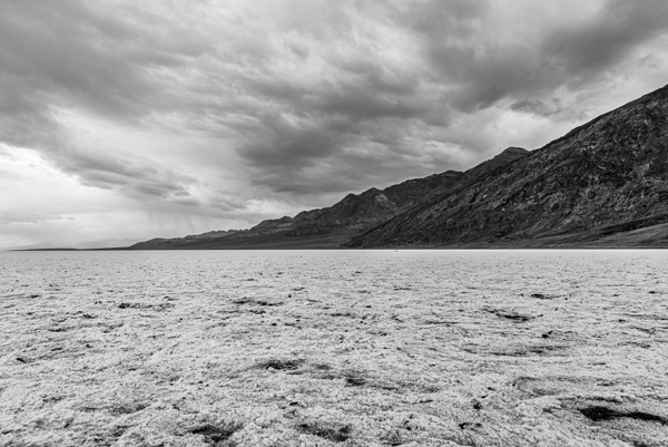Badwater Basin — Crusted salt runs toward dark mountains at Badwater Basin, the lowest ground in North America