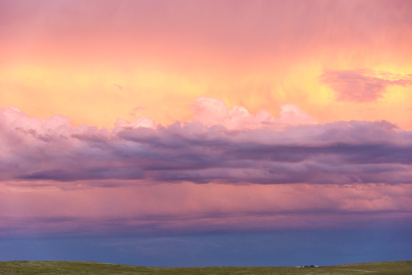 Pastel Clouds — Bands of pink and violet cloud drift over the South Dakota prairie at dusk